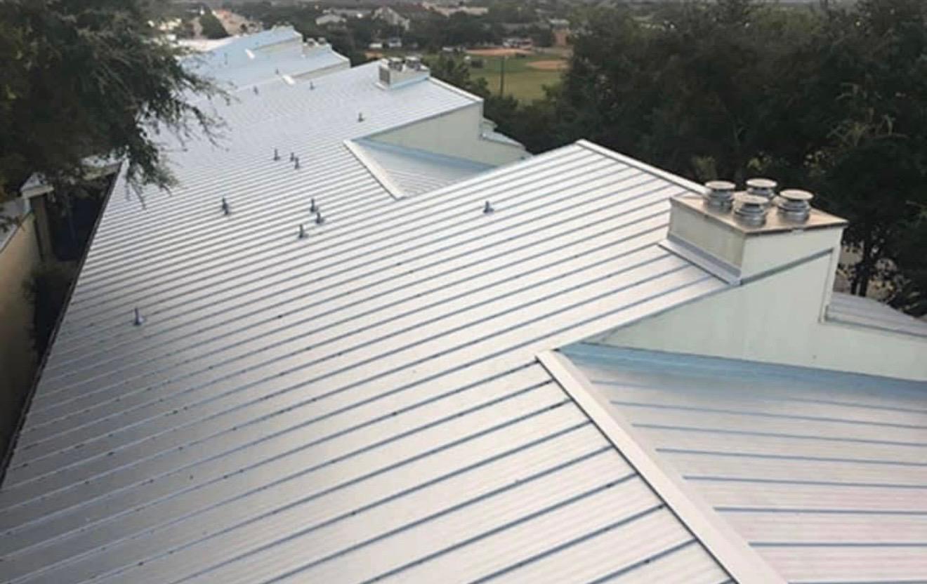 Aerial view of white standing-seam metal roof installation - 1st Capital Certified Roofing Austin TX