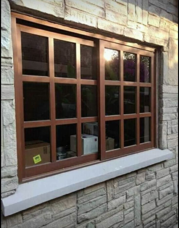 Dark wood frame multi-pane windows on stone wall - 1st Capital Certified Roofing Austin TX